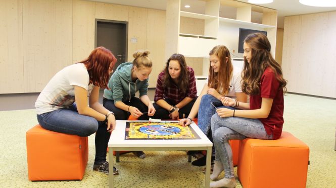 Schülerinnen vom Internat spielen ein Brettspiel