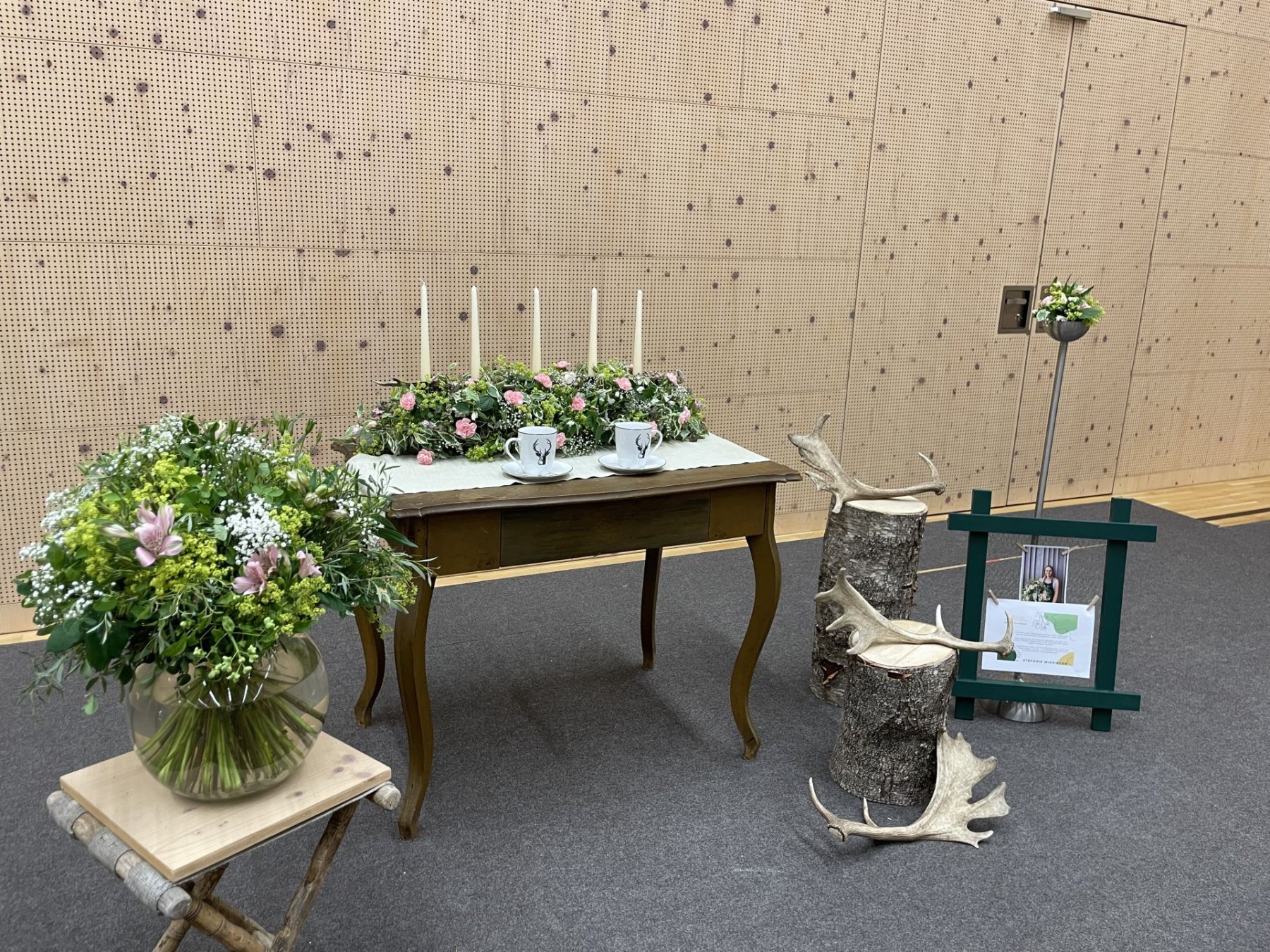 Tisch und Geweihe mit Blumenarrangements
